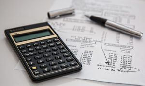 A calculator with a pen and financial statement 