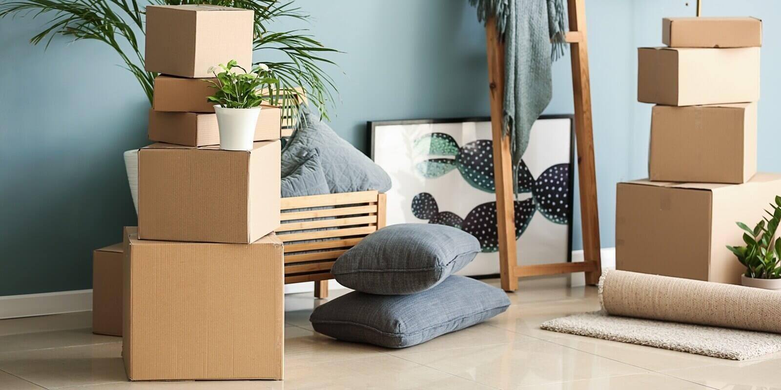 belongings and moving boxes near wall in room