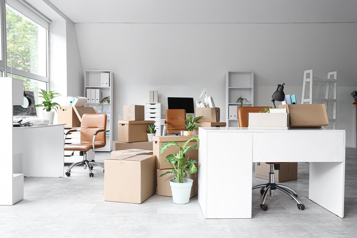 desks with cardboard boxes in office on moving day
