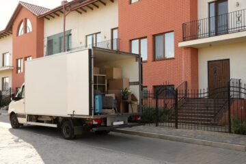 van full of moving boxes and furniture near house